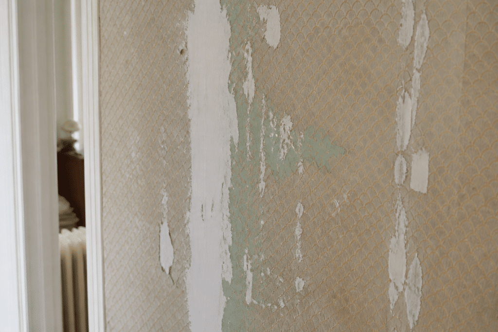 Mur ancien avec papier peint ecaille et traces de peinture