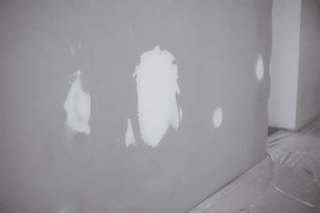 Enduit de rebouchage blanc sec sur mur gris