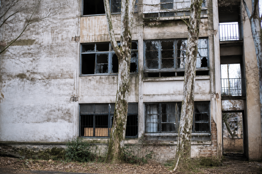 Immeuble résidentiel délabré avec fenêtres cassées et façade dégradée