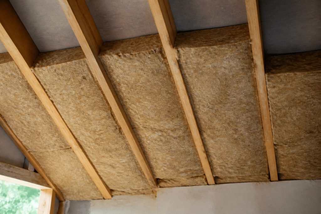 Rouleaux isolants installes entre chevrons de toiture bois