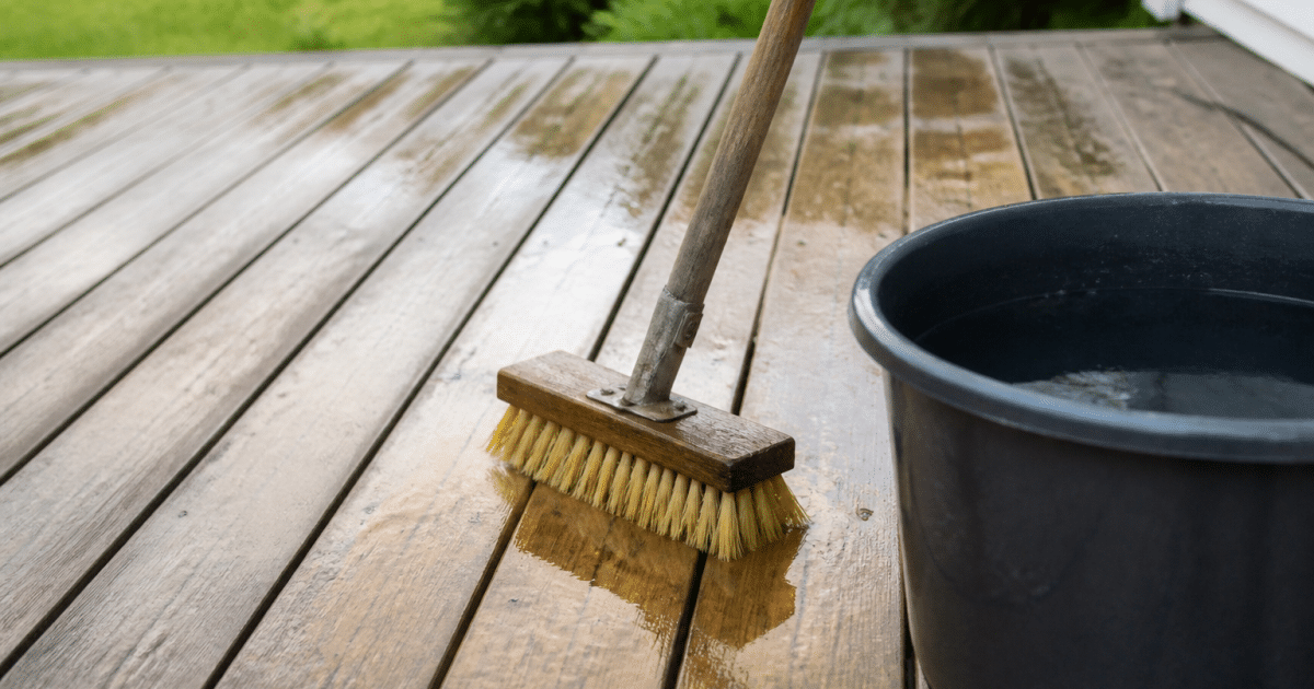 Brosse et seau d'eau nettoyant une terrasse bois horizontale