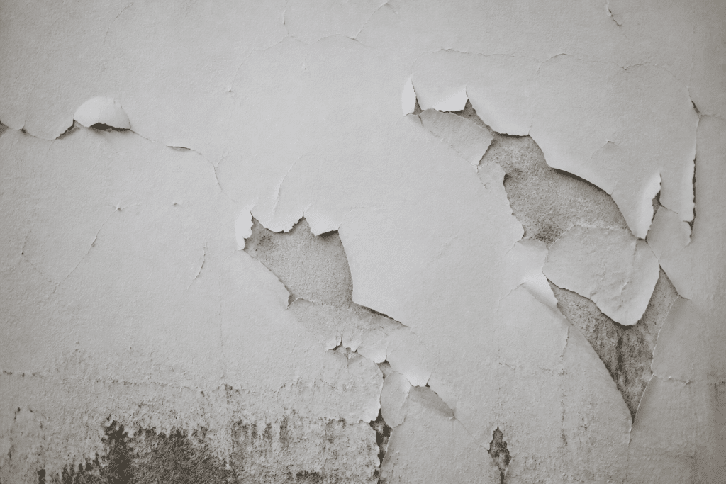 Mur blanc écaillé montrant peinture qui s'effrite et se détache