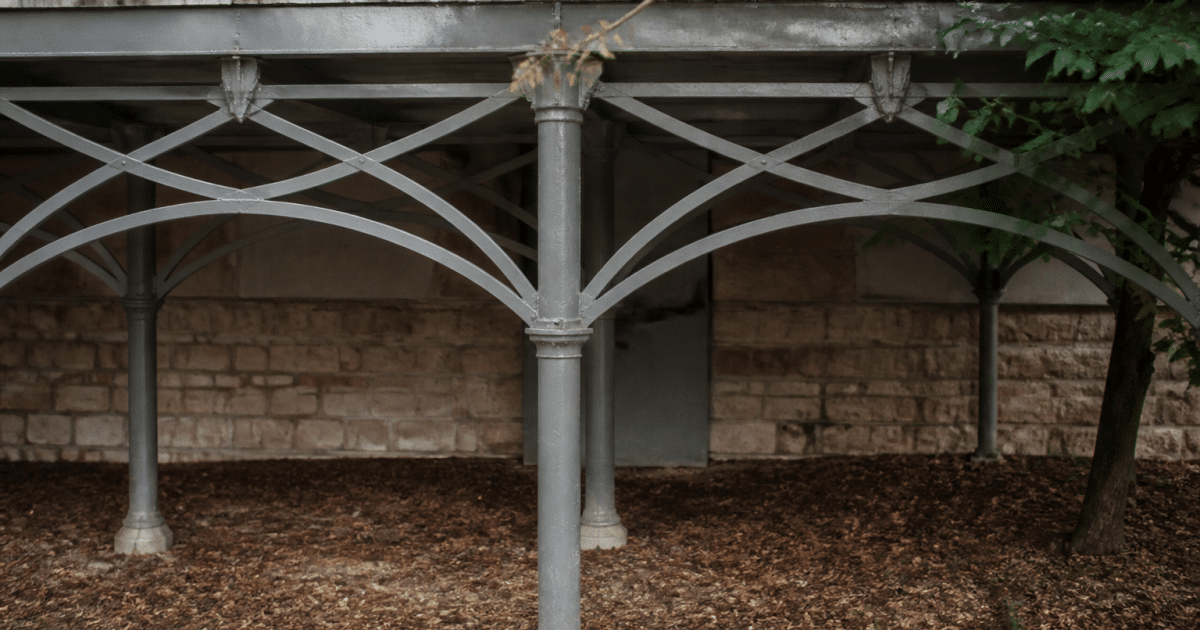 Structure metallique ornementale soutenant terrasse avec poutres entrecroisees