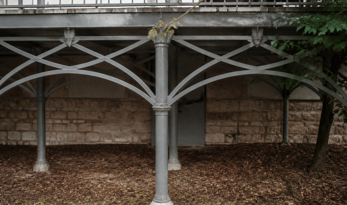 Structure metallique ornementale soutenant terrasse avec poutres entrecroisees