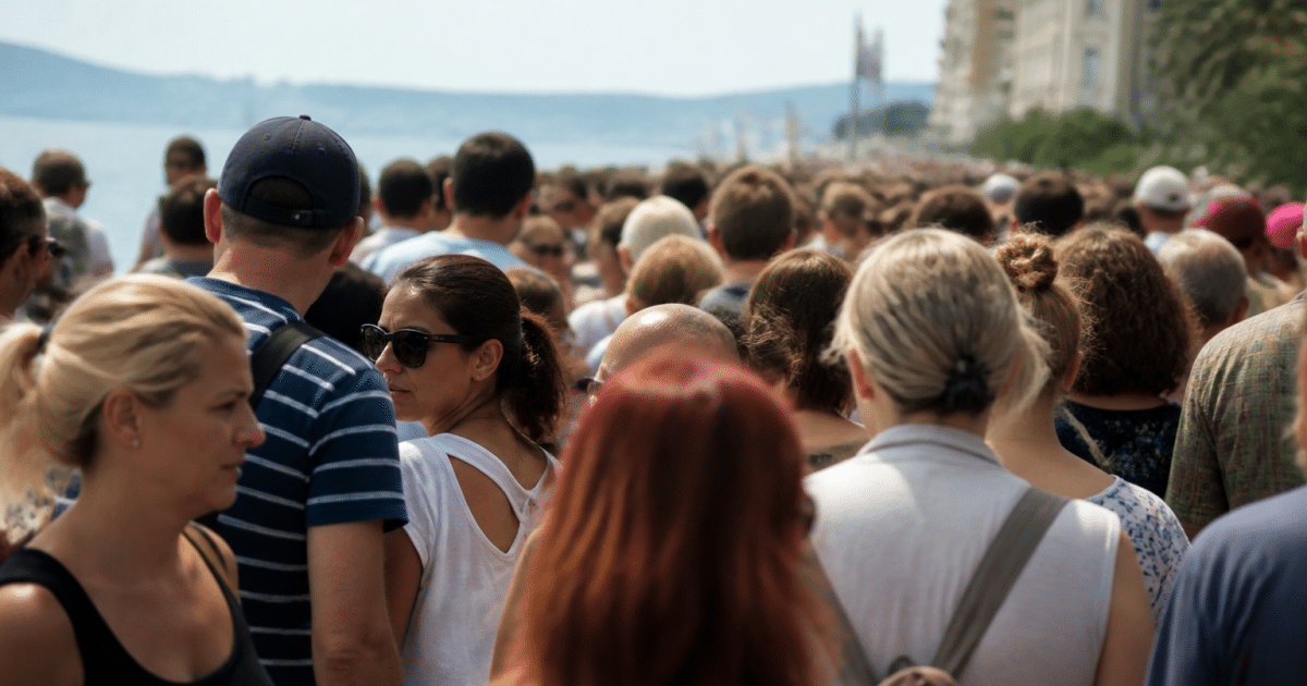 Foule dense de personnes debout dans rue urbaine côtière