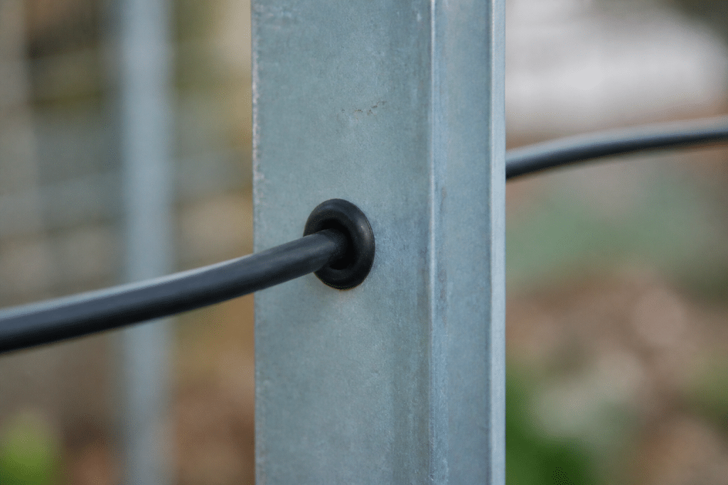 Cable passant dans montant metallique avec bague isolante protectrice