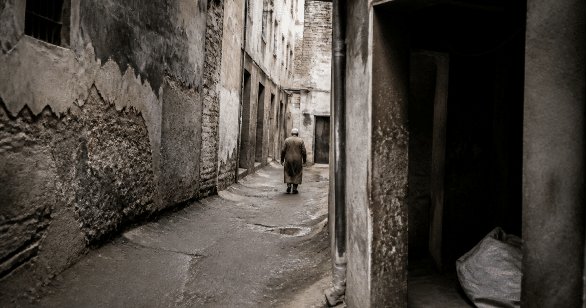 Rue urbaine defavorisee avec immeubles delabres et passages sombres