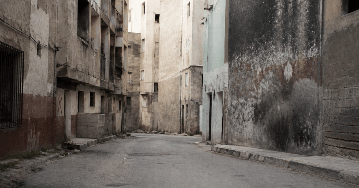 Rue urbaine deserte avec immeubles degrades et graffitis visibles
