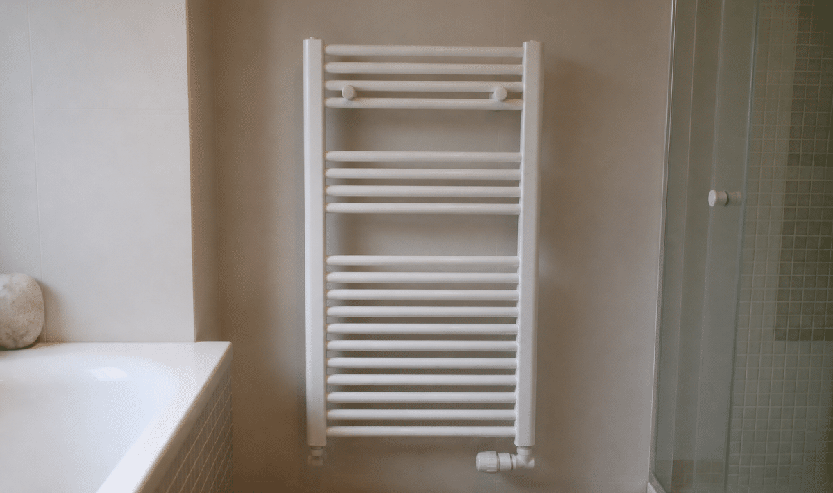 Radiateur blanc fixe au mur salle bain carrelée