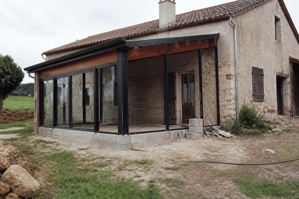Maison rurale avec veranda vitrée en construction incomplete
