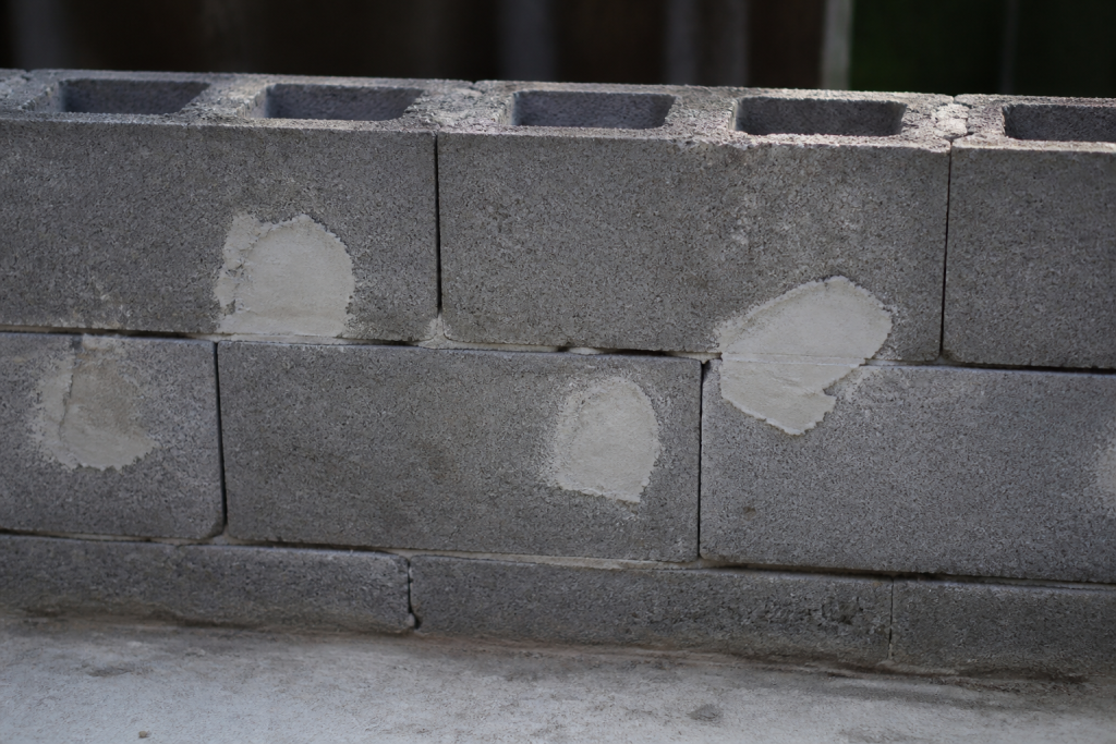 Bloc ciment gris avec trous rebouches mortier blanc