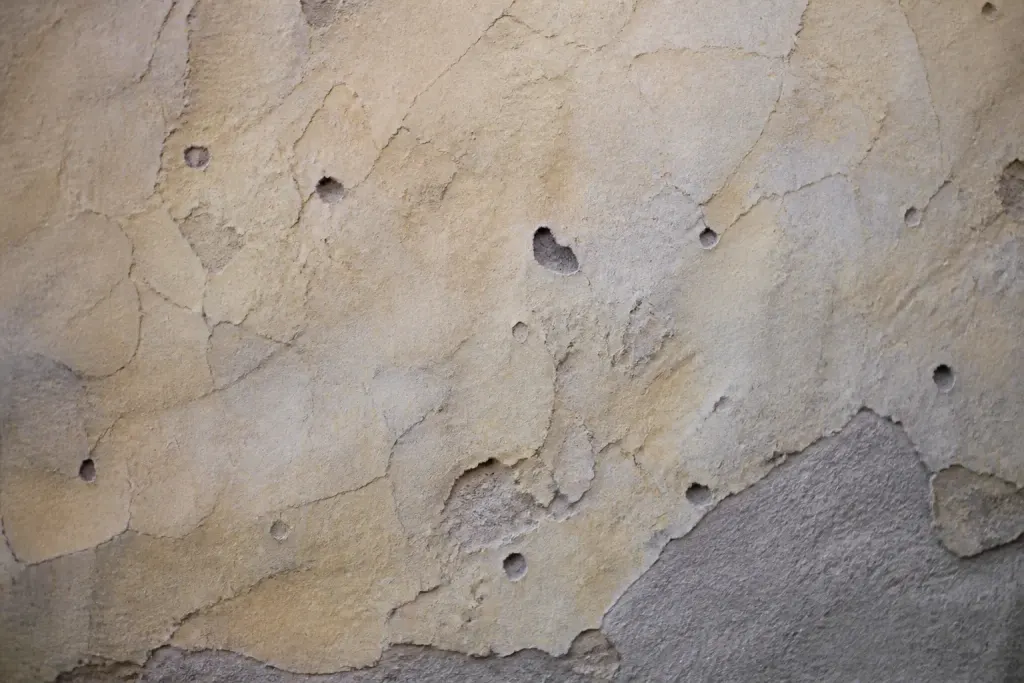 Mur ancien peint avec creux et bosses visibles