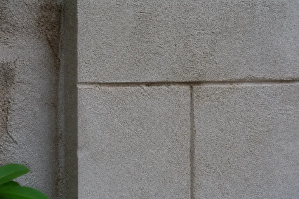 Mur de facade enduite, blocs sculptes et joints traces